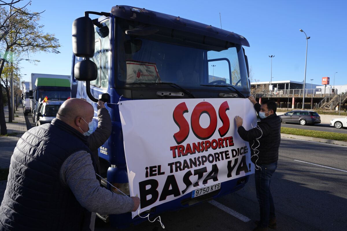 Drivers attach a banner to a truck that reads, "SOS, Transport. That's enough" before a protest in Madrid earlier this week.