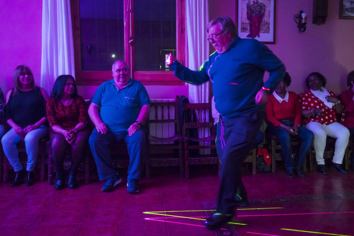 Manuel Gozalo dances as others look on. (Angel Navarrete / For the Times)