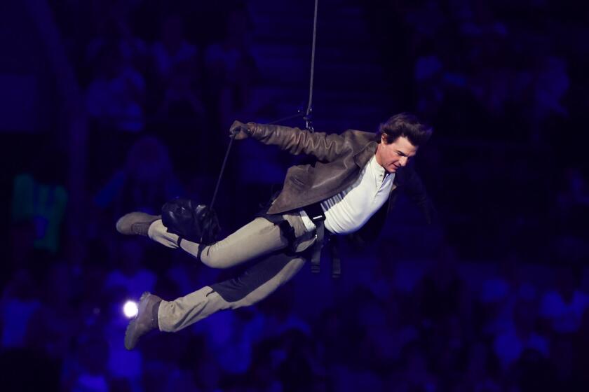 Tom Cruise repels from the top of State de France during the closing ceremony of the 2024 Paris Olympics.