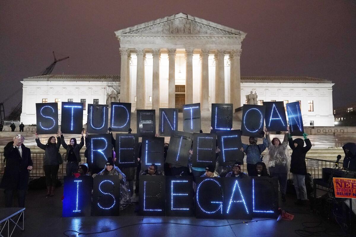 Student debt relief advocates gather outside the Supreme Court, spelling out "Student loan relief is legal." 