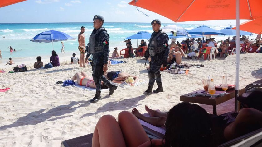 This photo taken on Jan. 18, 2017, shows Mexican Federal Police patrolling a beach in Cancun, Mexico, where a shooting occurred in a nightclub the day before. Despite past problems, Cancun scored thousands of new visitors during the hurricanes that struck the Caribbean.