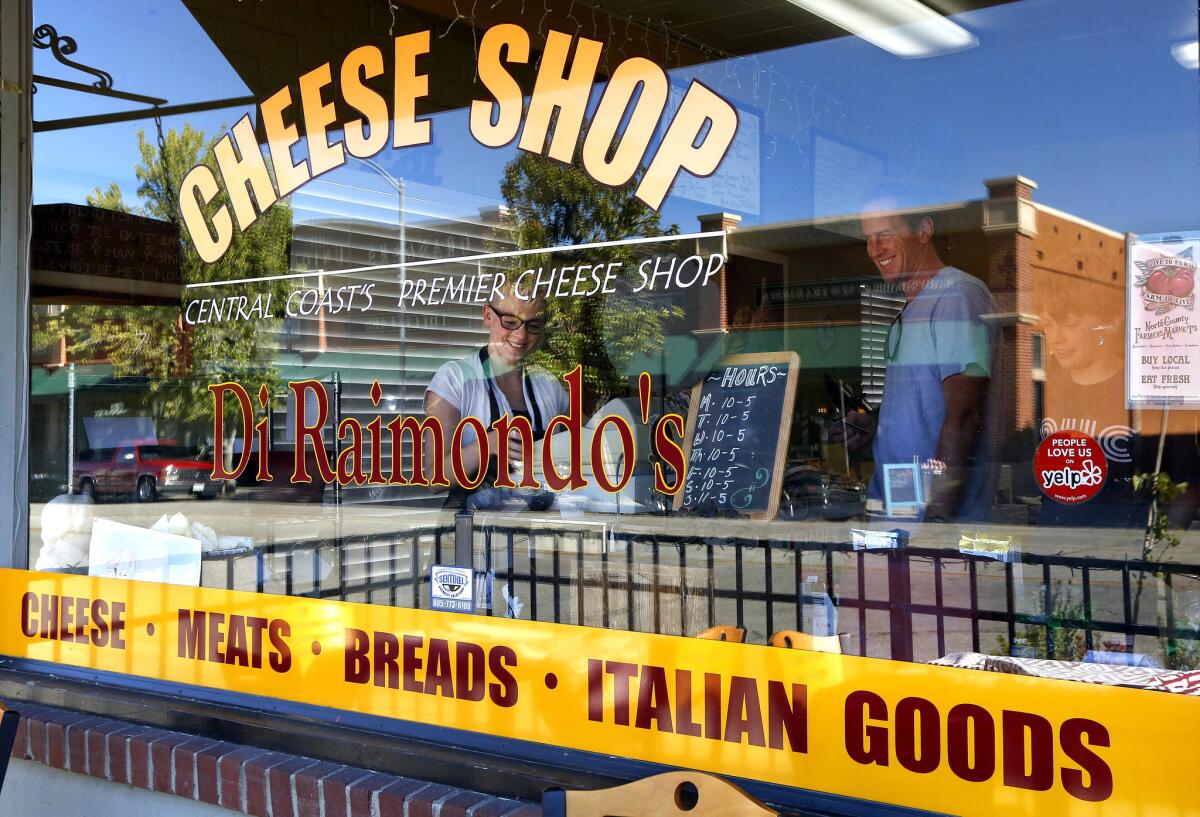 Alyssa Mead rings up customer Michael McGean, from Bend, Ore., inside Di Raimondo's Cheese Shop in downtown Paso Robles.