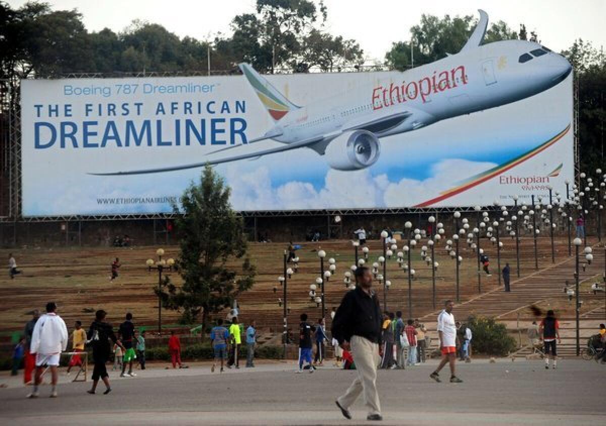 People walk past a billboard in Addis Ababa showing an Ethiopian Airlines Boeing 787 Dreamliner.