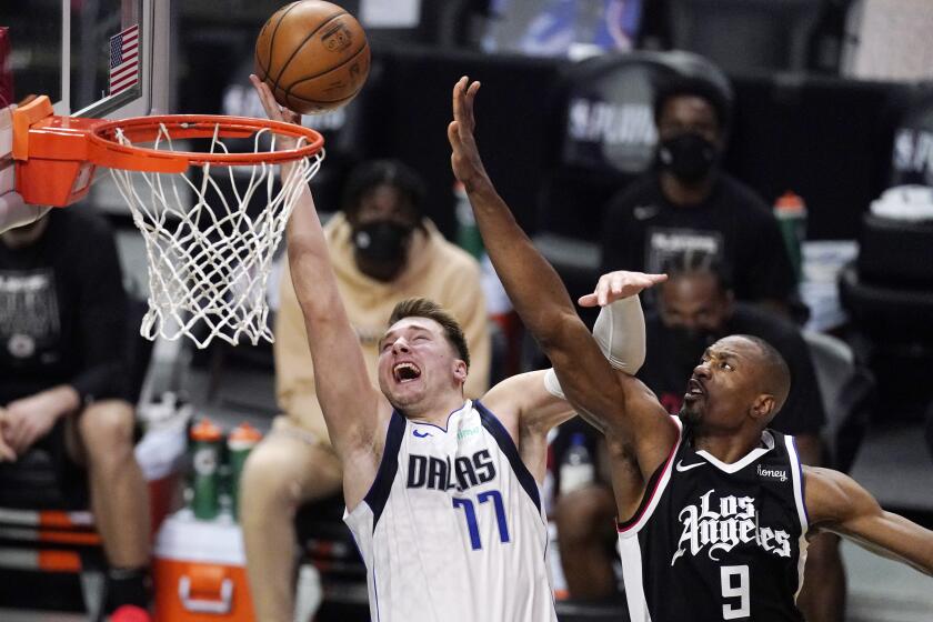 Dallas Mavericks guard Luka Doncic, left, shoots as Los Angeles Clippers center Serge Ibaka defends during the second half in Game 1 of an NBA basketball first-round playoff series Saturday, May 22, 2021, in Los Angeles. (AP Photo/Mark J. Terrill)