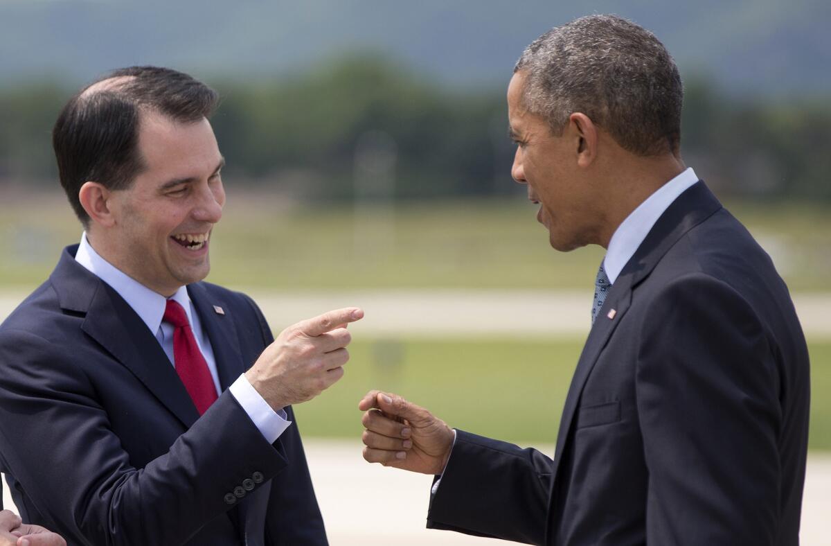 President Obama talks with Wisconsin Gov. Scott Walker as he arrives in La Crosse, Wis., on Thursday.