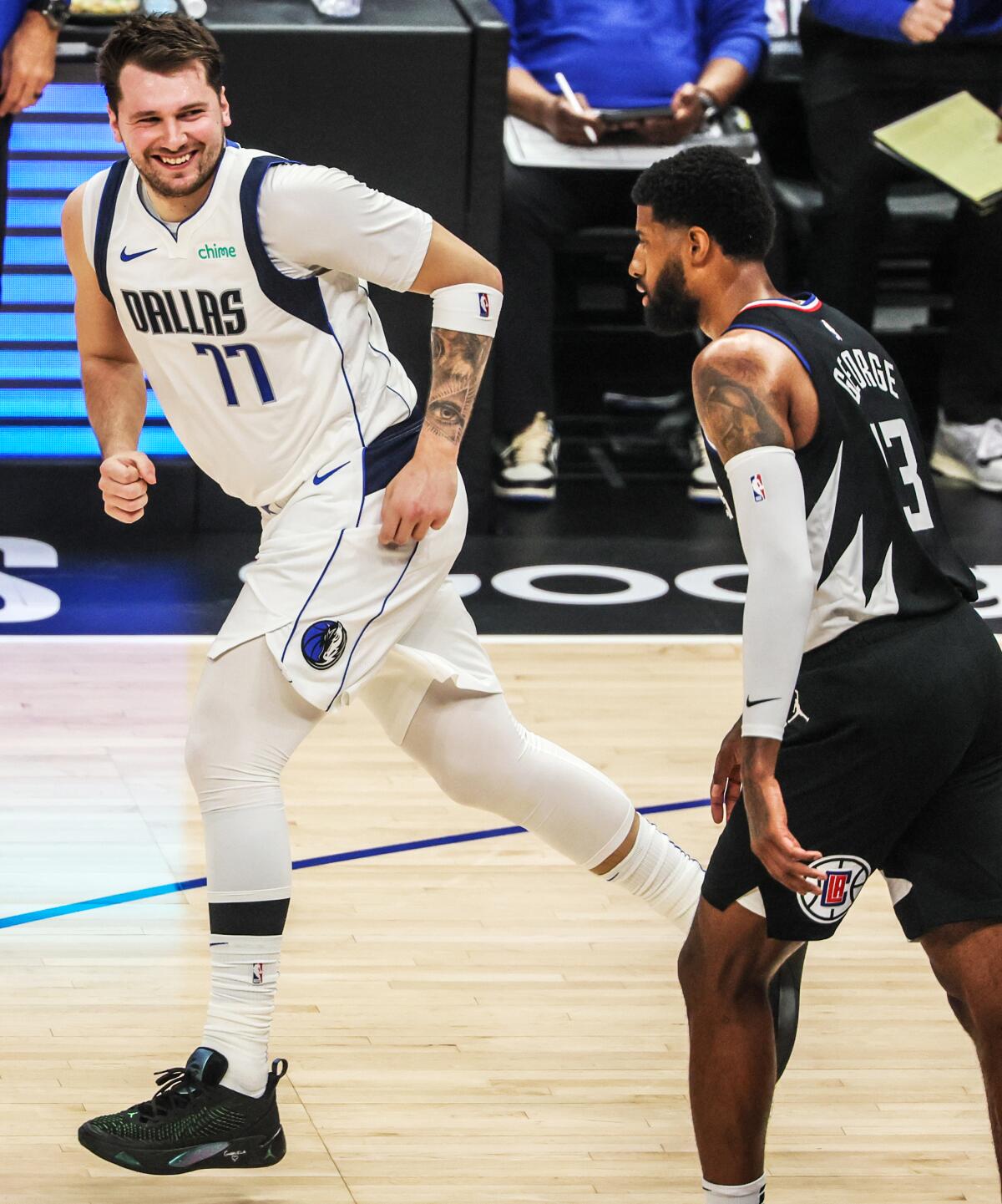 Mavericks guard Luka Doncic, left, offers a wry smile to Clippers forward Paul George after making a basket in Game 2.