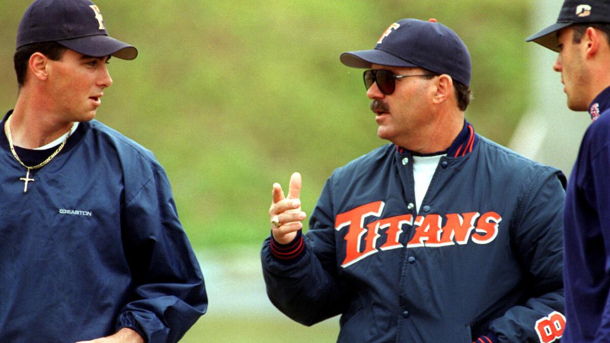 C.J. Ankrum (left) talks with Fullerton coach George Horton during a practice in January 1997.
