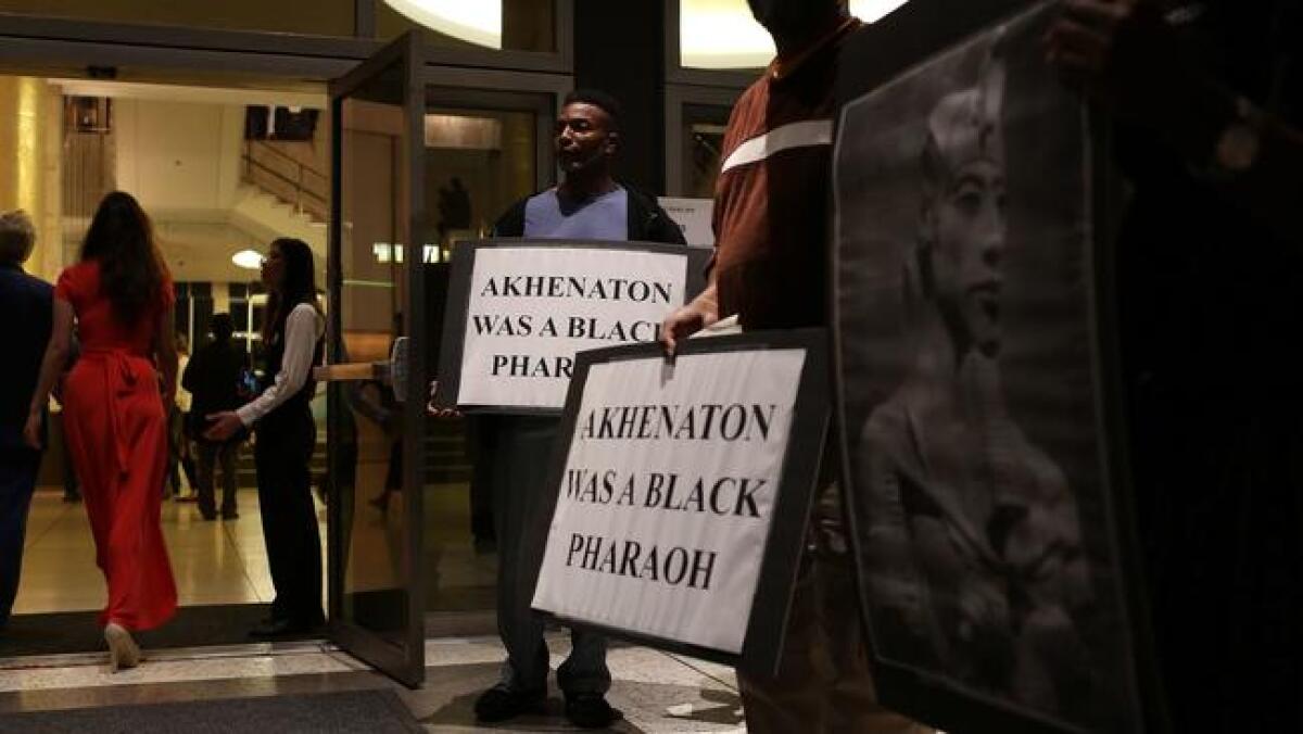 Kamal Mohsin holds a protest sign with other demonstrators outside Dorothy Chandler Pavilion on Saturday night.