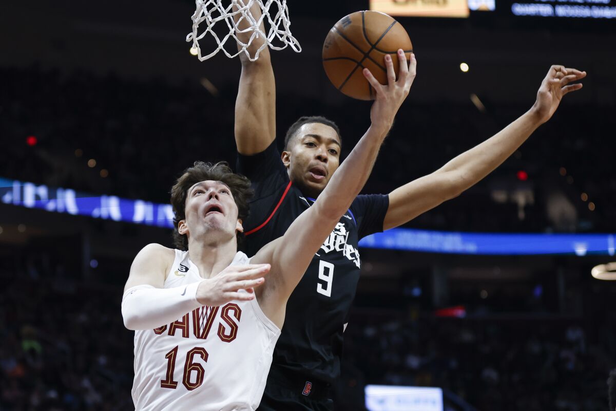 Cleveland Cavaliers forward Cedi Osman (16) shoots against Los Angeles Clippers center Moses Brown (9) during the second half of an NBA basketball game, Sunday, Jan. 29, 2023, in Cleveland. (AP Photo/Ron Schwane)