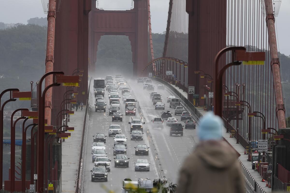 A person watches as traffic drives across the Golden Gate Bridge in Sausalito.