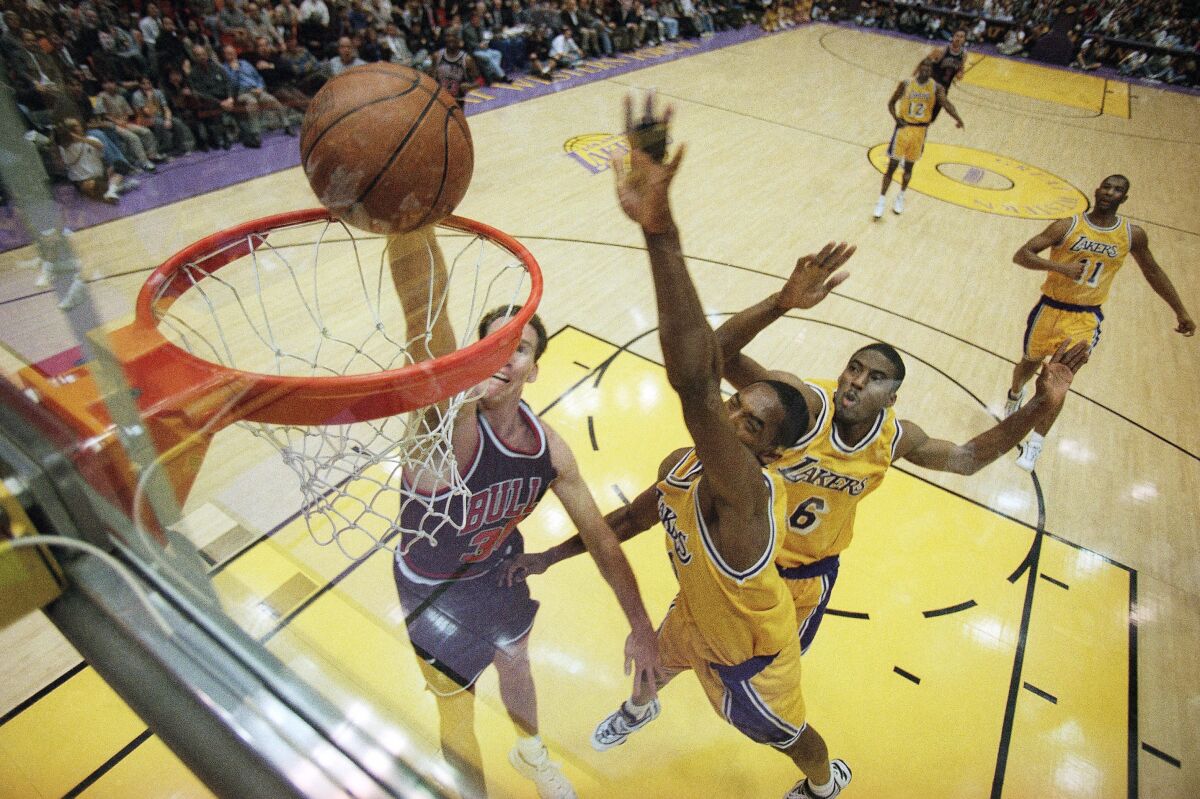 Chicago Bulls’ Jud Buechler dunks the ball against the Lakers’ Kobe Bryant (center) and Eddie Jones during a game Feb. 5, 1997, at the Forum in Inglewood.