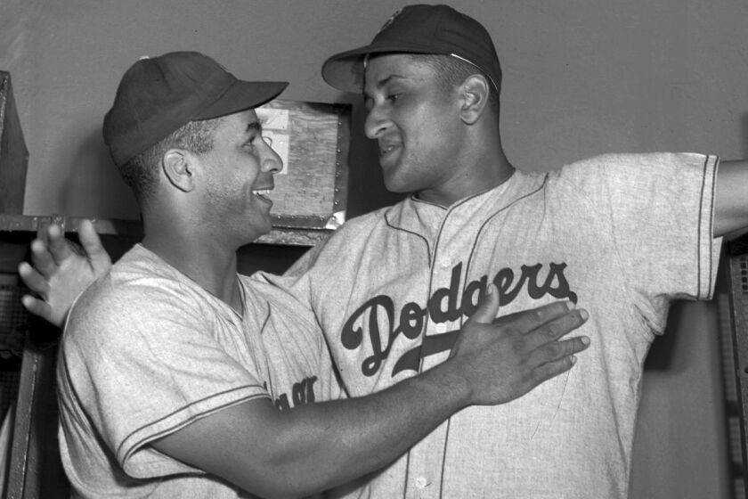 FILE - Brooklyn Dodgers catcher Roy Campanella, left, congratulates his battery mate, Don Newcombe, in the dressing room at the Polo Grounds in New York on Sept. 2, 1949. Holman Stadium in Nashua, N.H., is being recognized for hosting the country's first racially integrated baseball team, the Nashua Dodgers, in 1946. The club was a minor league league affiliate of the Dodgers, which included Hall of Famer Campanella and future Cy Young Award winner Newcombe. (AP Photo/Matty Zimmern, File)