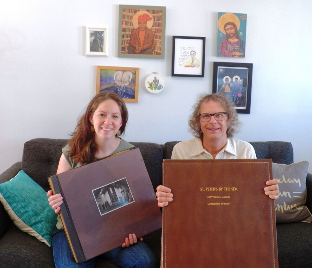 St. Peter’s pastor Rebekkah Lohrmann and Congregation Council member Fletcher Miller show albums of the church's history.