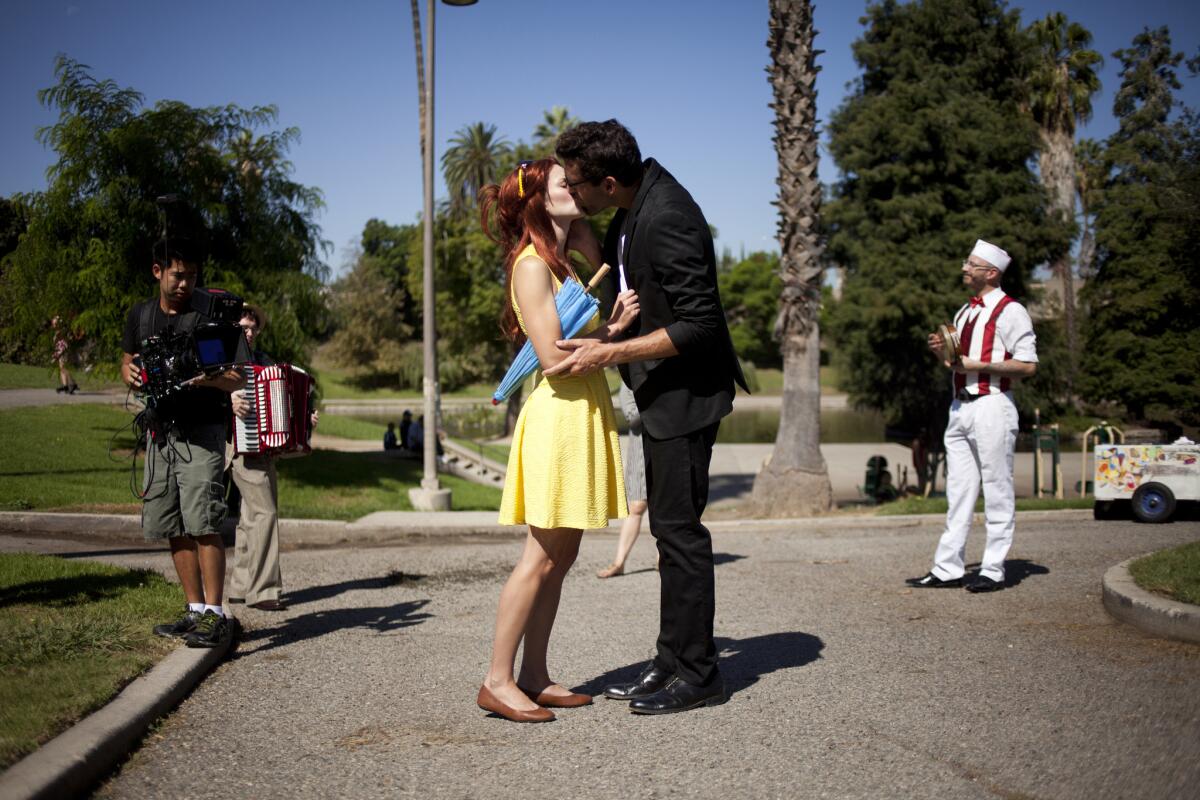 Performers Sarah Beaty and Victor Mazzone kiss during one of the stops in "Hopscotch," the opera-in-cars staged in Los Angeles by the experimental company the Industry.