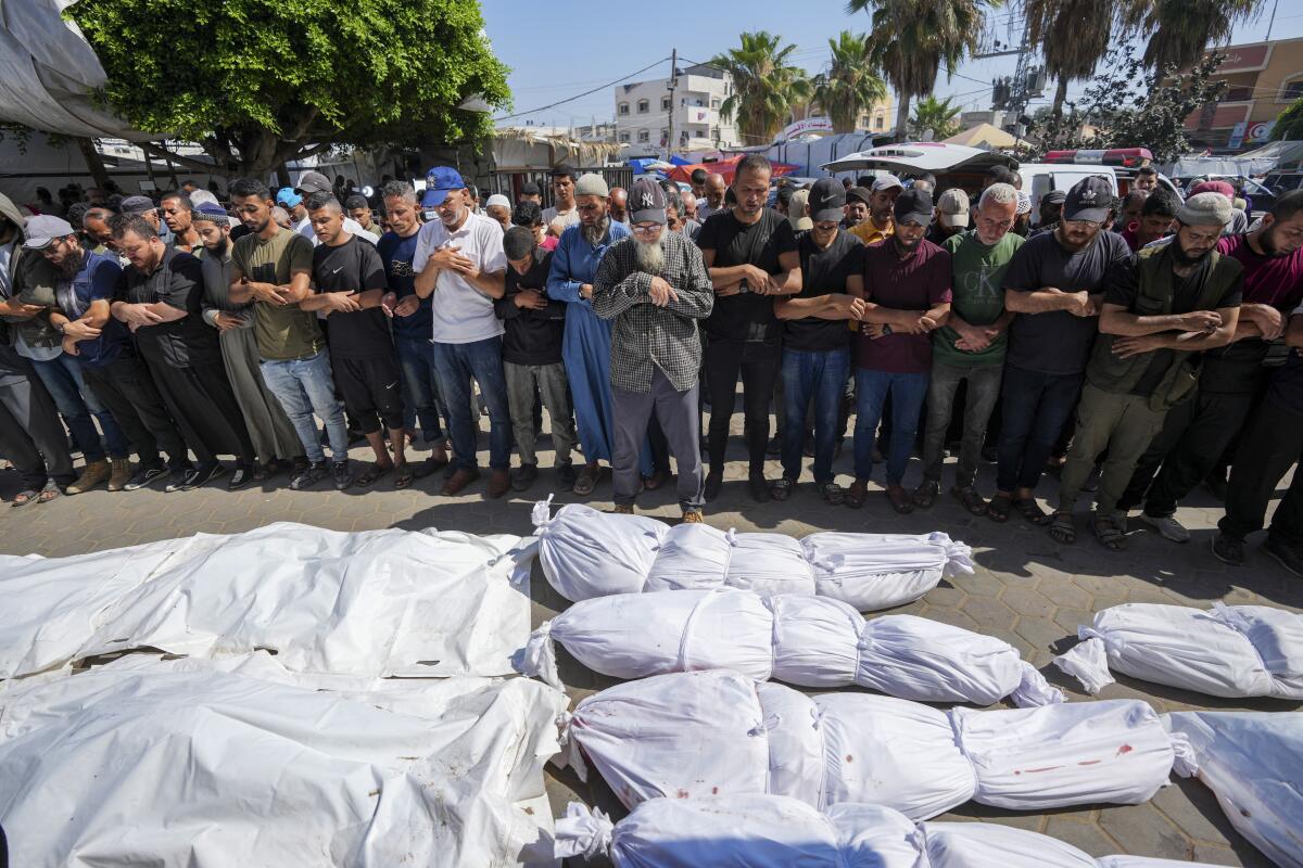Palestinians mourn relatives killed in an Israeli strike on a U.N.-run school in Gaza.