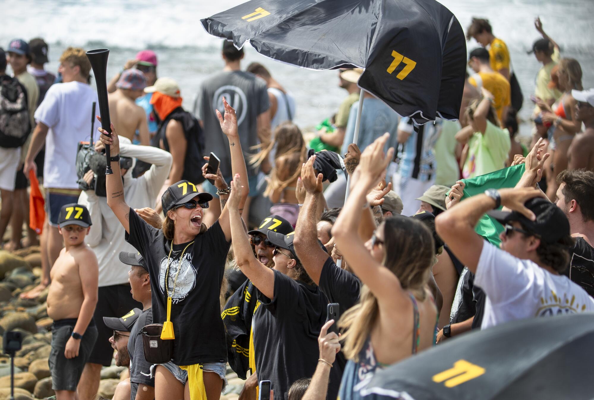 Fans cheer as Filipe Toledo competes in the championship round of the WSL Finals.