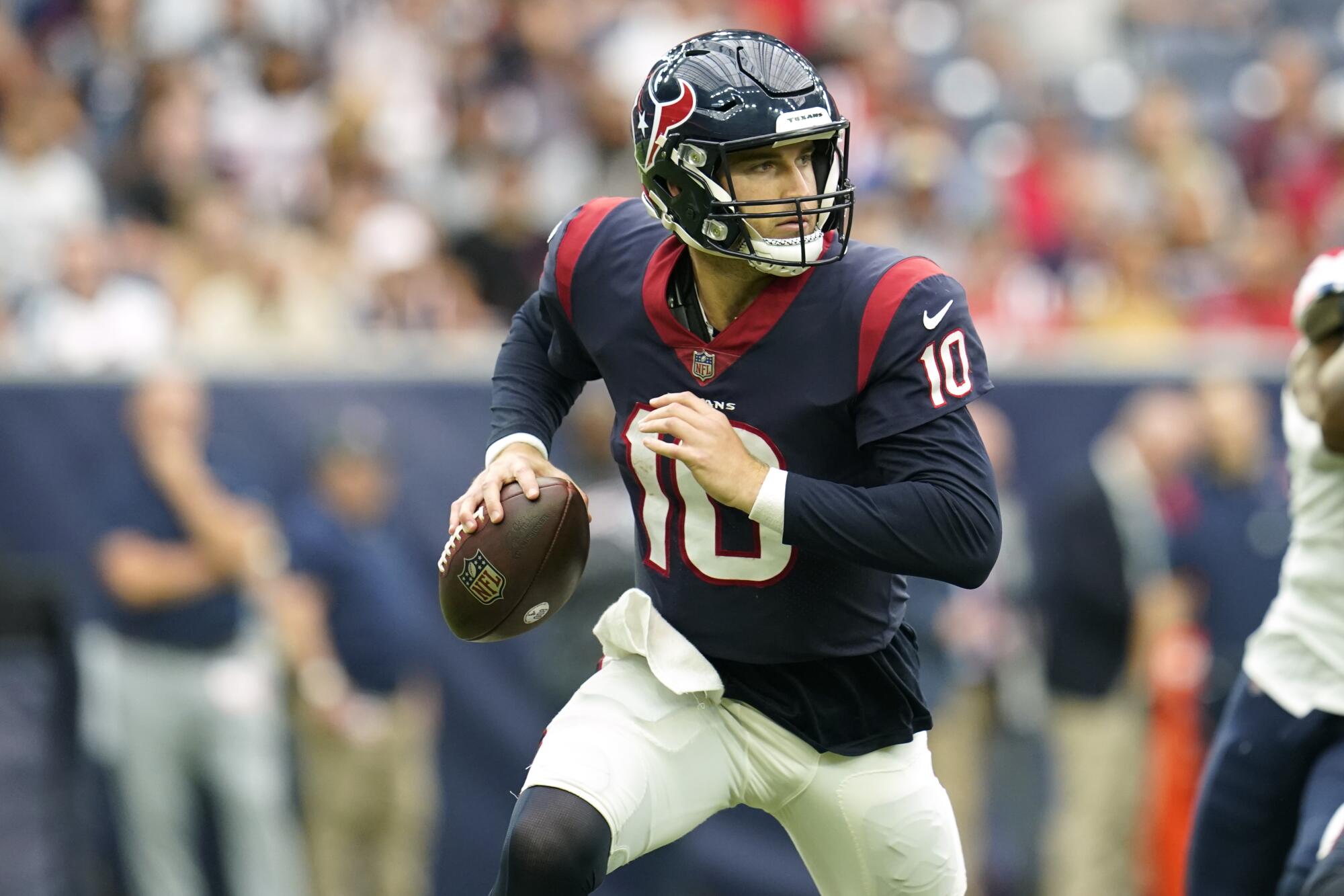 Houston Texans quarterback Davis Mills scrambles as he looks to pass.