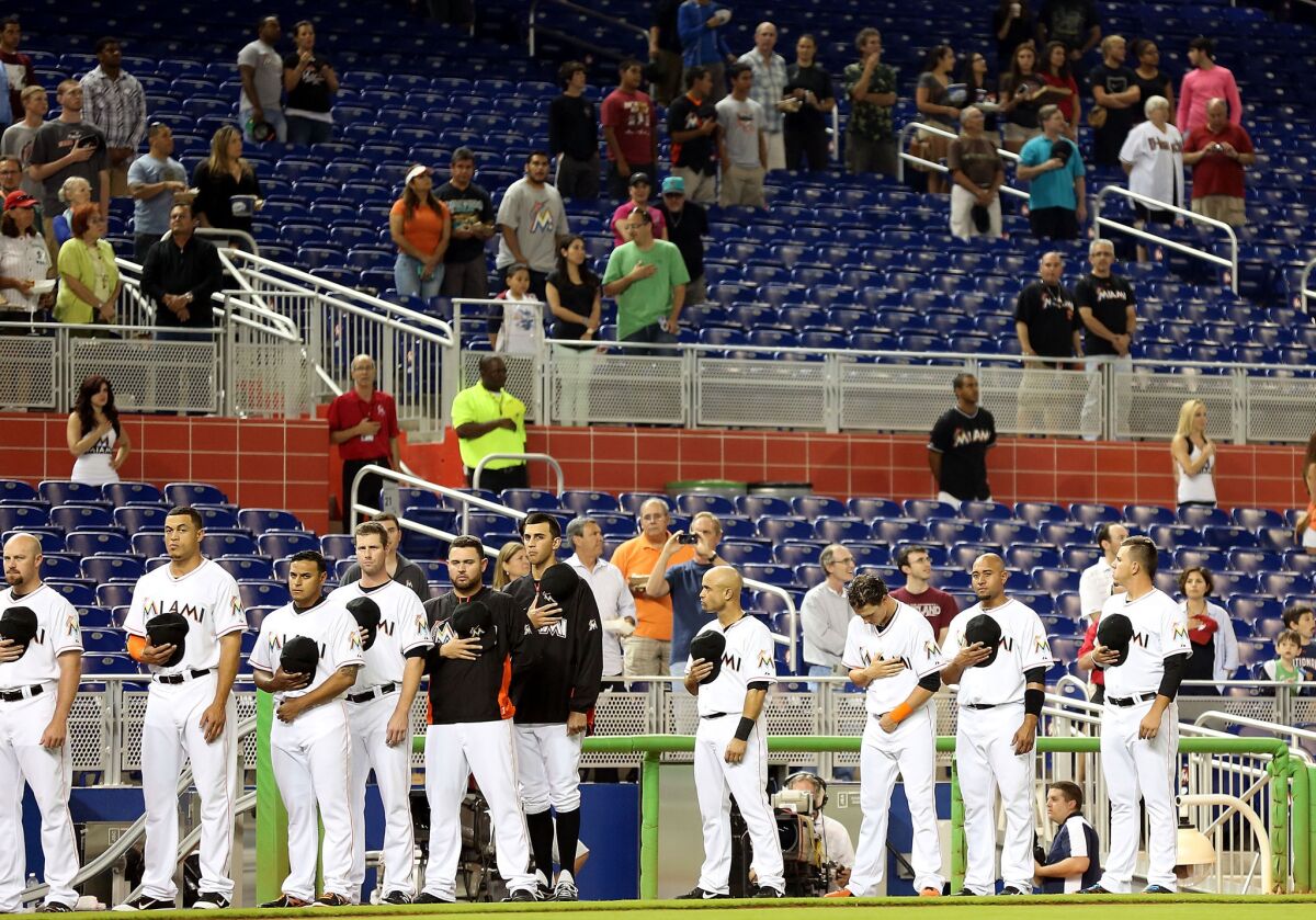 Miami Marlins players and fans stand for a moment of silence for the victims of the Boston Marathon attack prior to playing the Washington Nationals at Marlins Park in Miami.