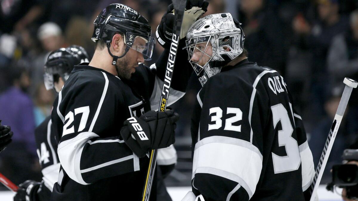 Kings defenseman Alec Martinez (27) and goalie Jonathan Quick celebrate after defeating the Boston Bruins, 2-1, on Saturday.