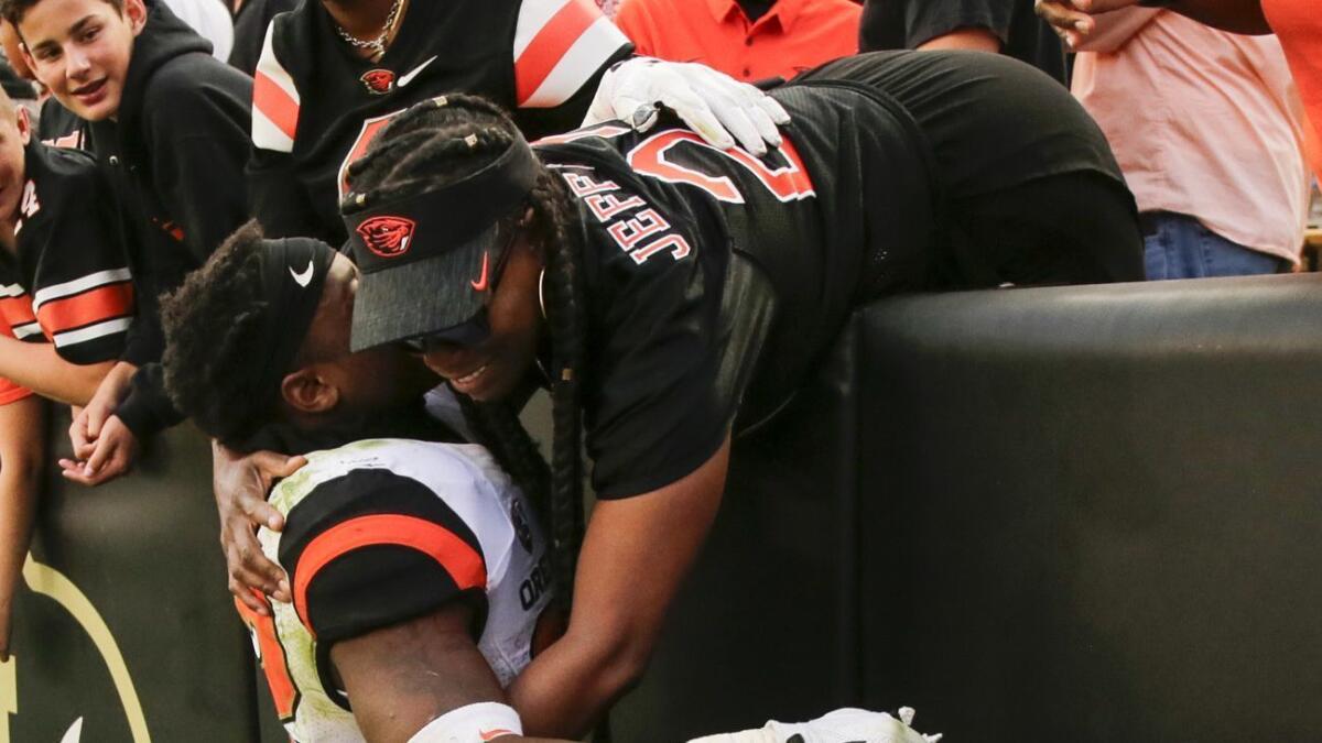 Oregon State Beavers running back Jermar Jefferson hugs his mother following a win against Colorado.