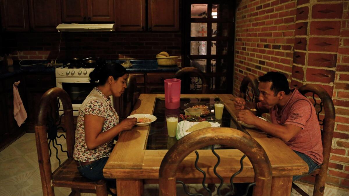 Gloria and German Almanza eat dinner in Malinalco, Mexico. They worked for years in the U.S. so they could build a nice family home in Mexico. Their U.S.-born children had other ideas.