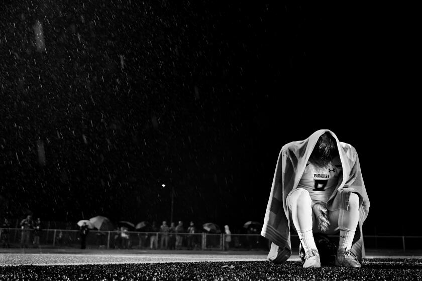 YUBA CITY, CALIFORNIA NOVEMBER 30, 2019-Paradise High School football player Brenden Moon sits alone in the end zone while rain comes down as the Bobcats lose the sectional championship in Yuba City, California Saturday. Brenden lost his home to the Camp Fire last year and lost his mother to suicide during the football season. (Wally Skalij/Los Angerles Times)