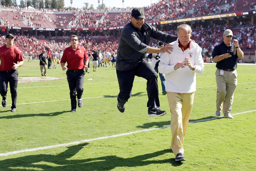 USC Coach Steve Sarkisian, center, jumps in celebration next to USC Athletic Director Pat Haden after the Trojans' win over Stanford in Palo Alto on Sept. 6. 2014.