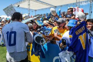 Fans clamor for an autograph from Chargers quarterback Justin Herbert.