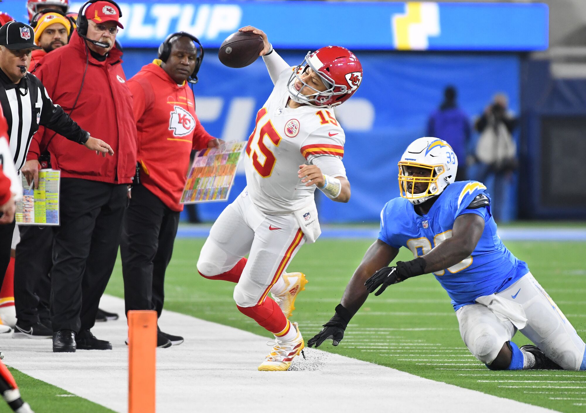 Chiefs quarterback Patrick Maholmes is pushed out of bounds by Chargers defensive lineman Justin Jones.