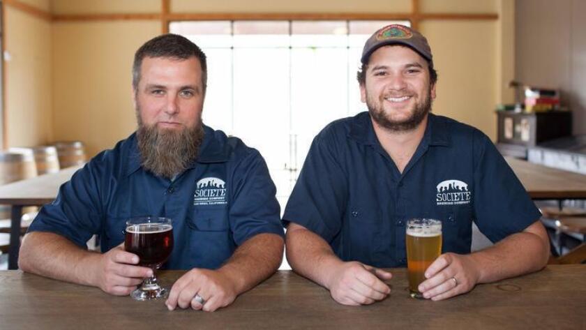 Travis Smith and Douglas Constantiner, founders of Societe Brewing Company, relax before customers start to arrive. (Brogen Jessup)