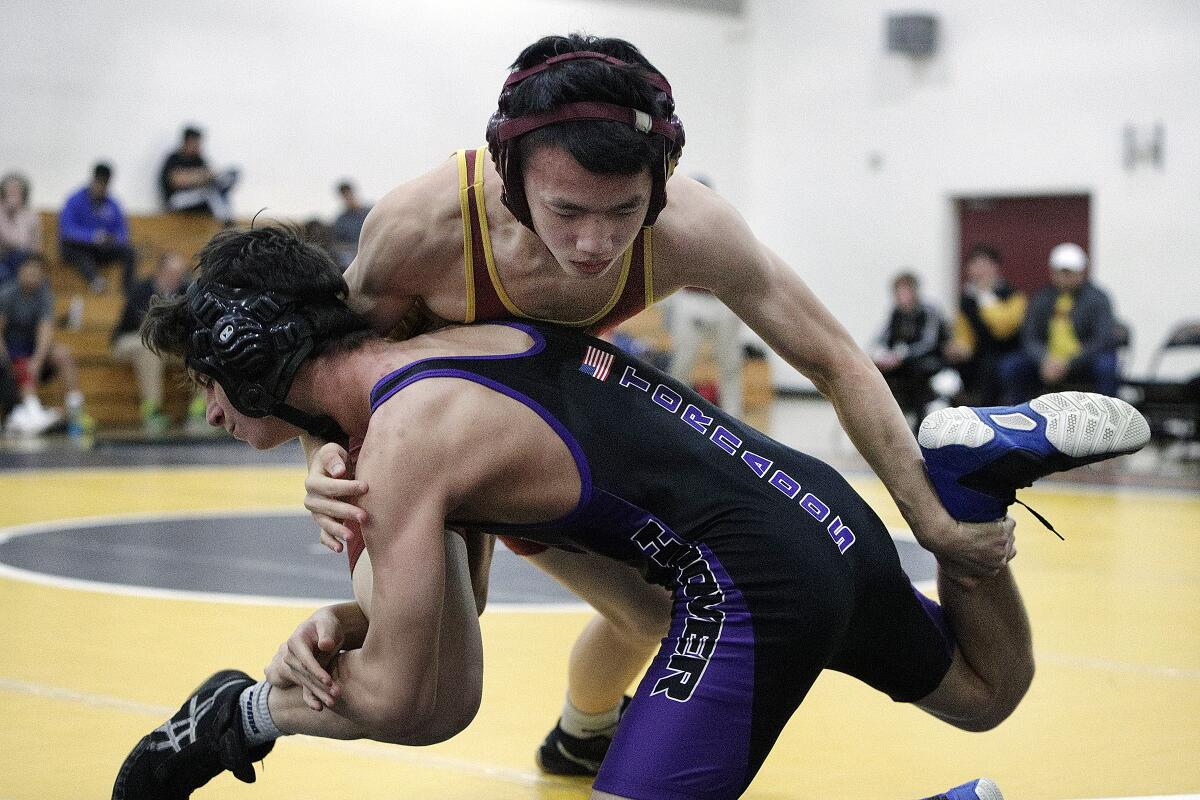 La Canada's Nicholas Wu nearly takes position on Hoover's Zachary Acosta before falling out of bounds in the 126 pound bout in a Rio Hondo League wrestling match at La Canada High School on Monday, January 13, 2020. La Canada won several matches unchallenged when Hoover did not post a wrestler for a weight class. La Canada won the meet.