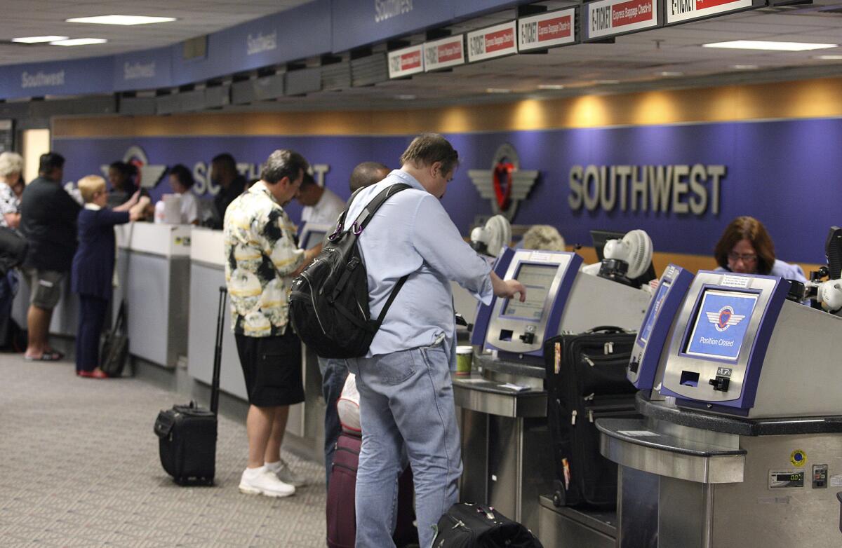 ARCHIVE PHOTO: Passengers wait in line at the Southwest counters at the Bob Hope Airport in Burbank.