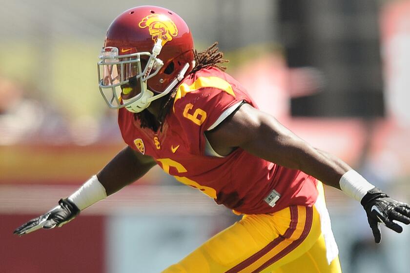 USC cornerback Josh Shaw celebrates after making a tackle during a game against Boston College in September 2013. Shaw suffered two high ankle sprains while rescuing his nephew from a swimming pool Monday.