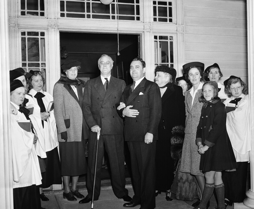 President Franklin Roosevelt is flanked by wife Eleanor, left, and an aide and family members in New York on Nov. 21, 1940.