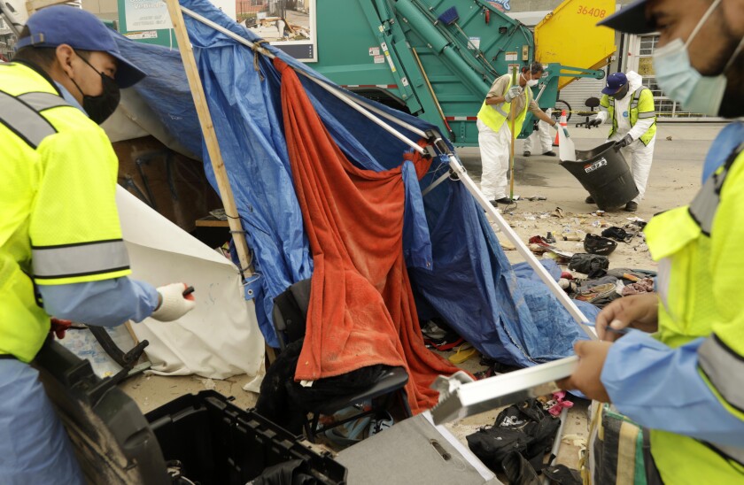 Workers clear a homeless encampment 