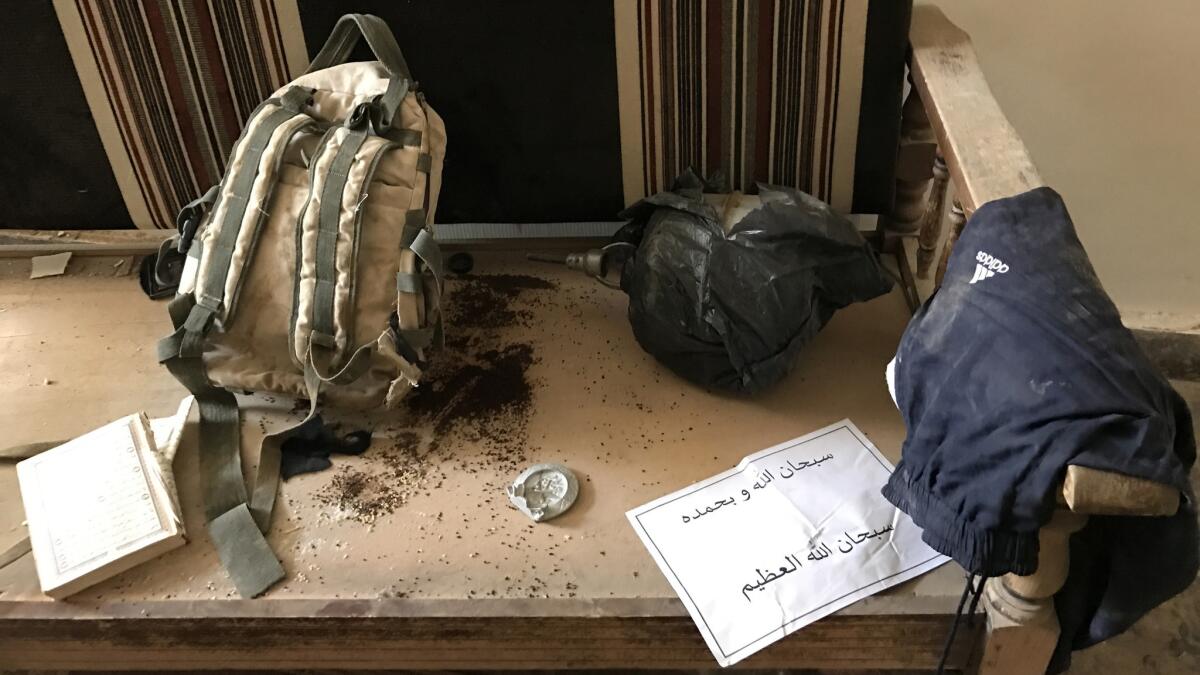 An abandoned backpack, ammunition and clothing at the entrance of an apparent explosives factory in Palmyra.