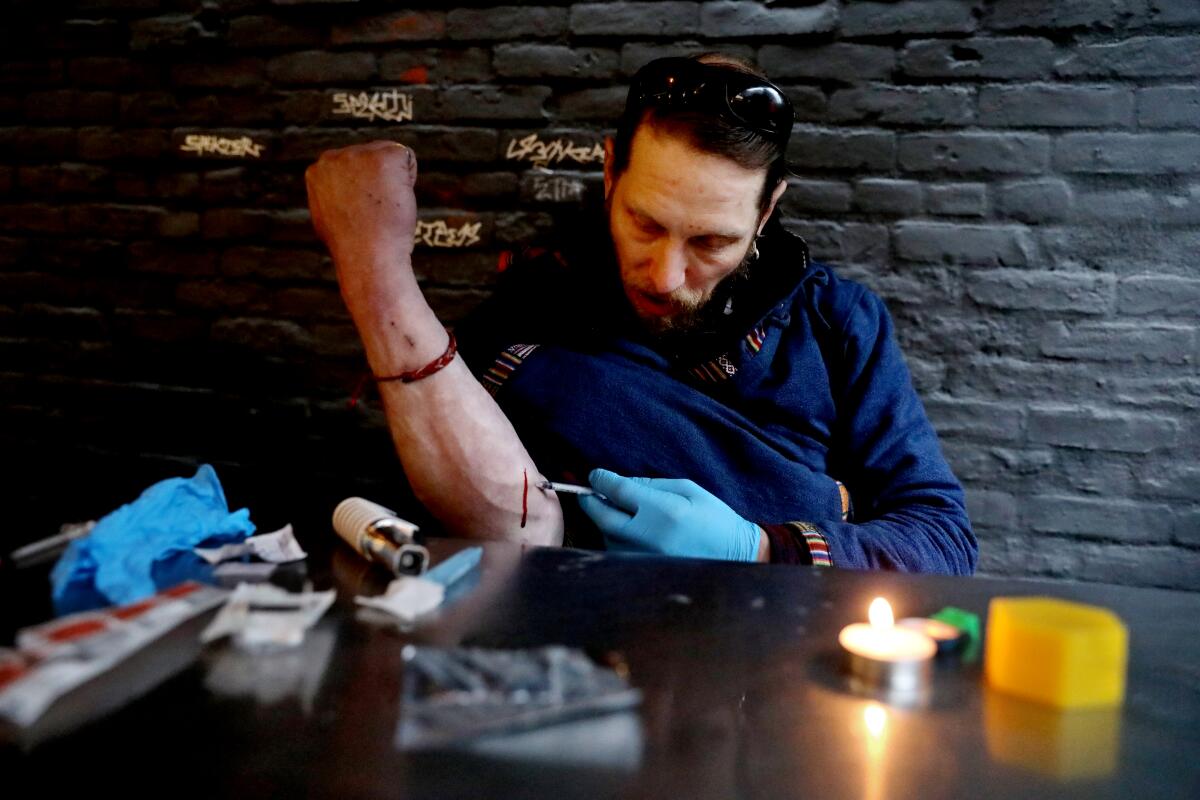 A man injects drugs into his arm.