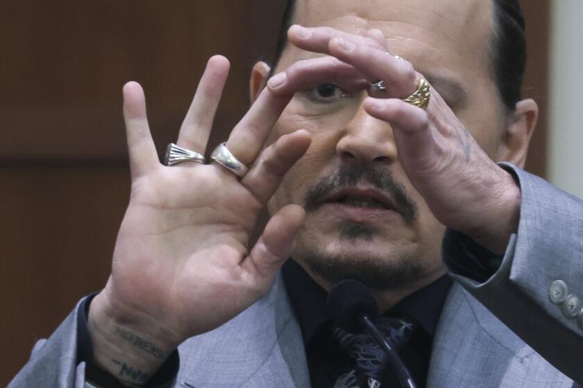 Johnny Depp displays the middle finger of his right hand while on the witness stand in court