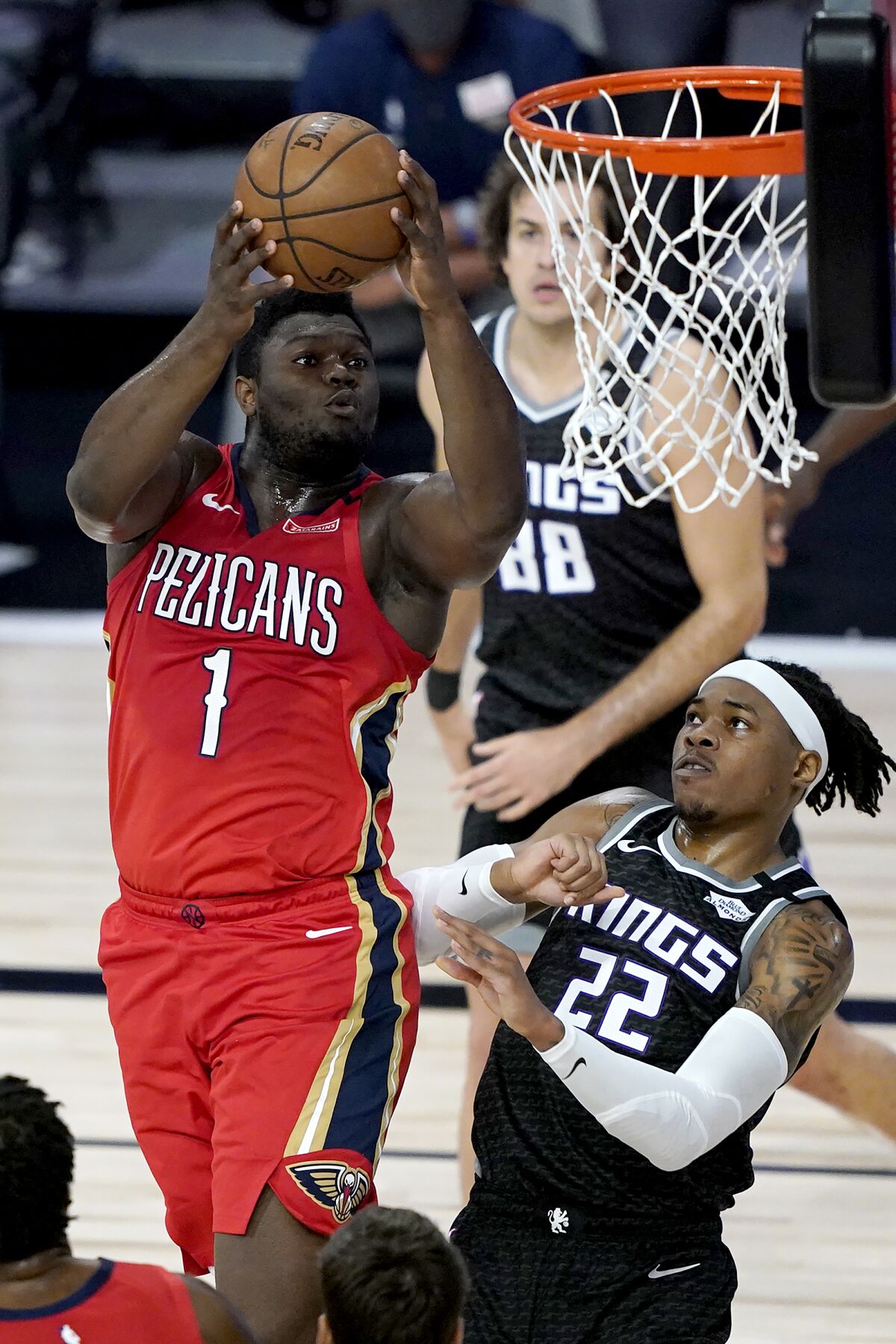 New Orleans Pelicans' Zion Williamson (1) goes up for a shot against Sacramento Kings' Richaun Holmes (22) during the first half of an NBA basketball game Thursday, Aug. 6, 2020 in Lake Buena Vista, Fla. (AP Photo/Ashley Landis, Pool)