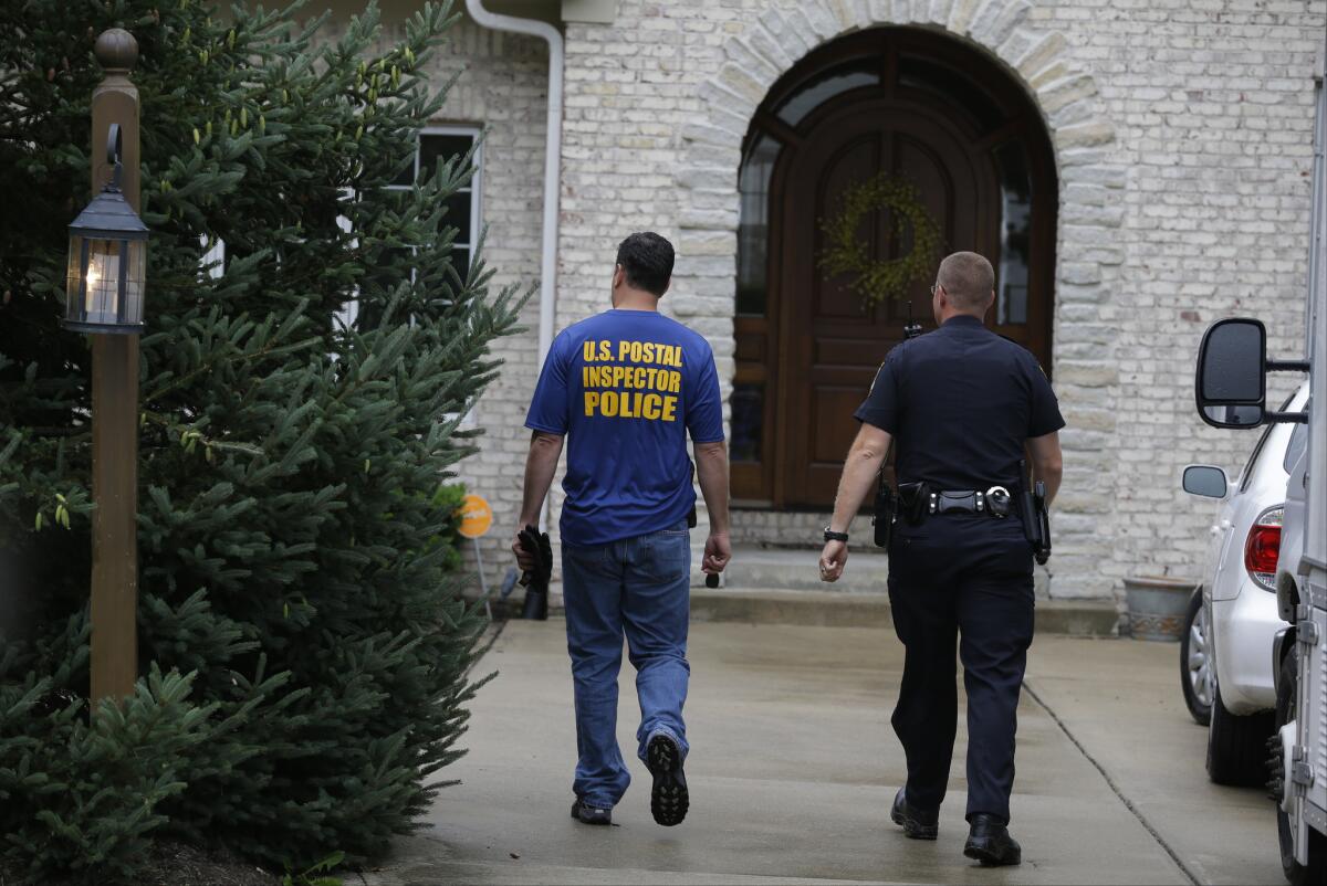 Federal authorities walk outside of the home of Subway restaurant spokesman Jared Fogle, Tuesday, July 7, 2015, in Zionsville, Ind. FBI agents and Indiana State Police have removed electronics from the property. (AP Photo/Michael Conroy)