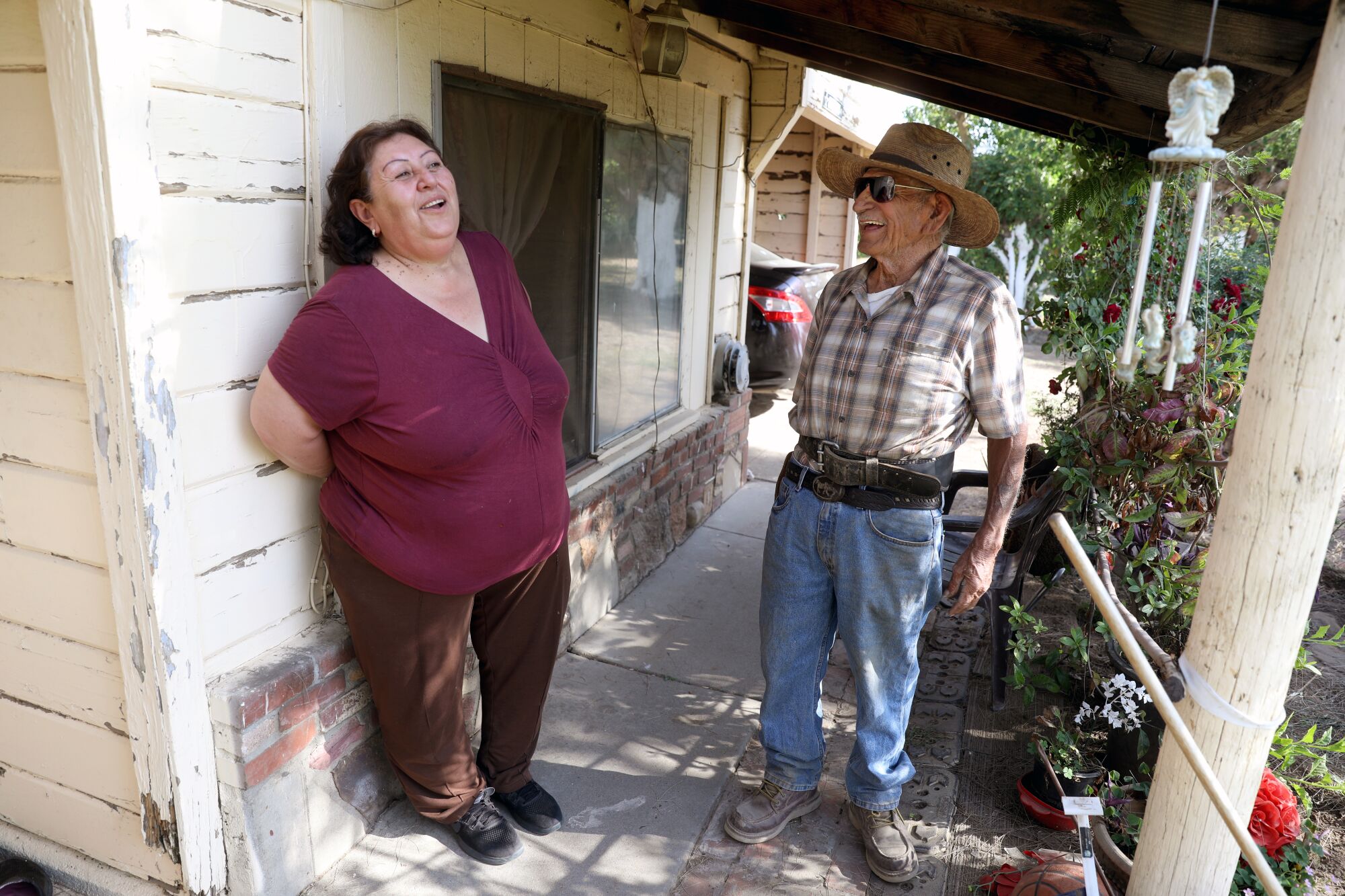 Jovita Torres with her friend and neighbor, Rodolfo Romero, outside a house. 