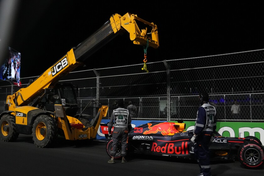Race marshals lift a car from Red Bull driver Max Verstappen of the Netherlands after he hit a wall during qualifying for the Saudi Arabian Grand Prix in Jiddah, Saturday, Dec. 4, 2021. (AP Photo/Hassan Ammar)