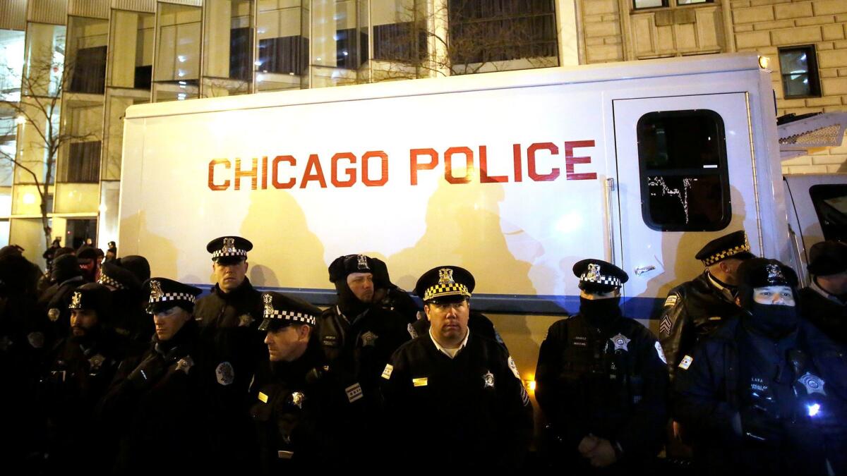 Chicago police stand watch in 2015 as demonstrators protest the fatal police shooting of 17-year-old Laquan McDonald. That shooting, in October 2014, and other incidents led to policy changes on the use of force.