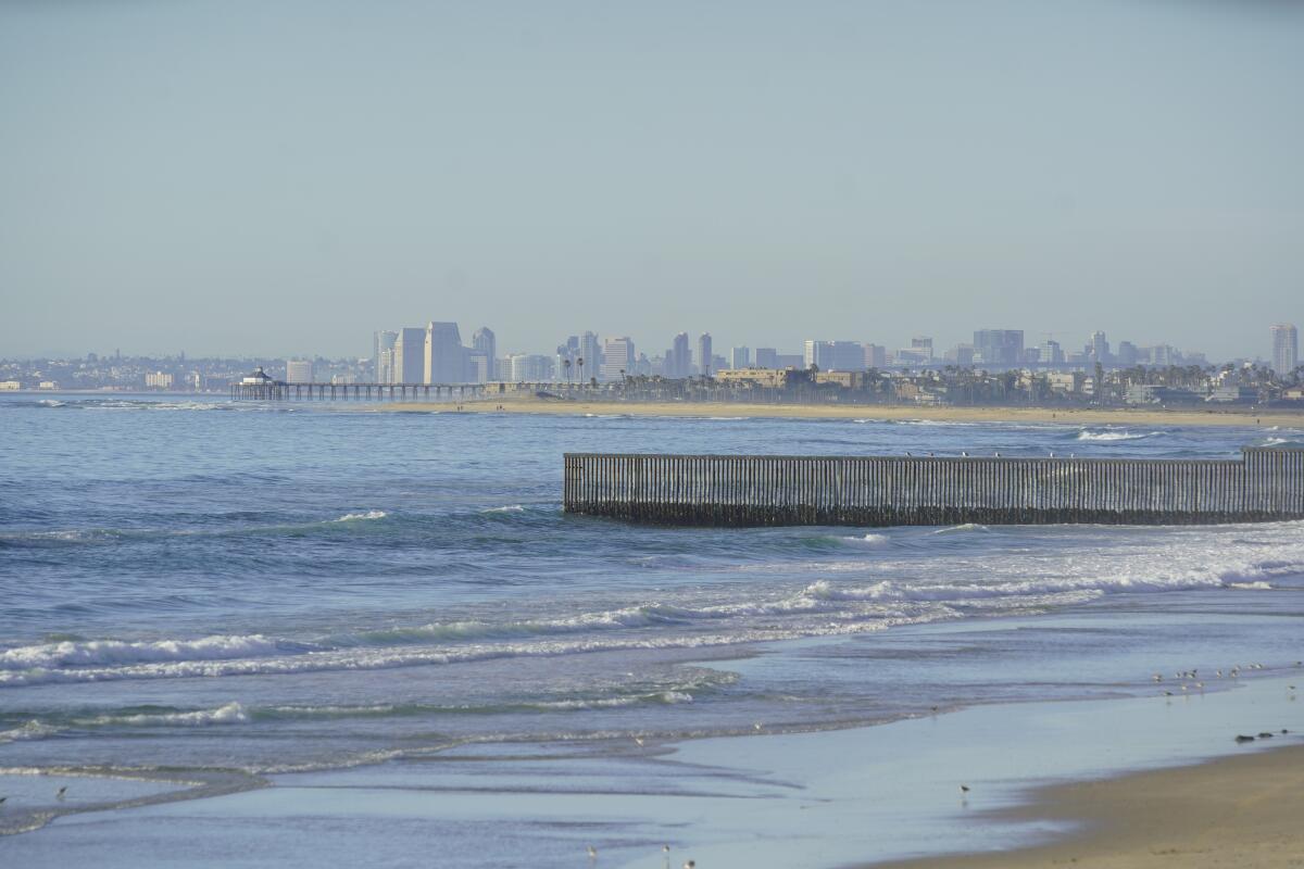 A border fence and San Diego's skyline as seen from Tijuana. The cities together are seeking to be World Design Capital.