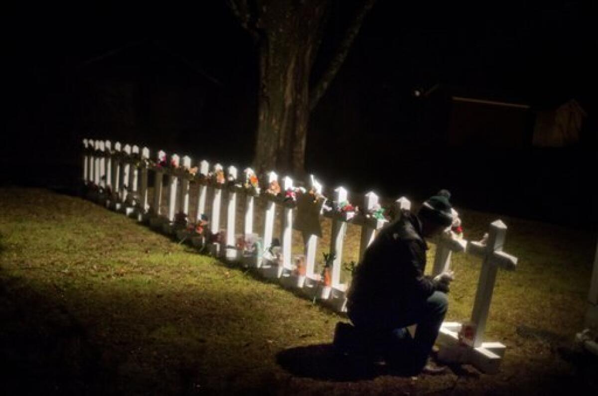 Frank Kulick tends a Sandy Hook memorial on his front lawn in Newtown, Conn.