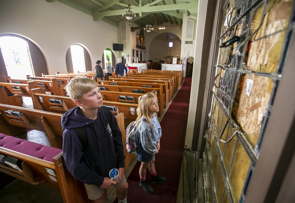  Cole and Heidi Jongeward look at the damage to a stained-glass window at Christ Church by the Sea.