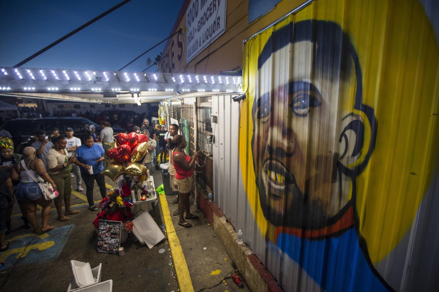Protesters gather in front of a mural painted on the wall of the convenience store where Alton Sterling was shot and killed, July 6, 2016 in Baton Rouge, Louisiana.