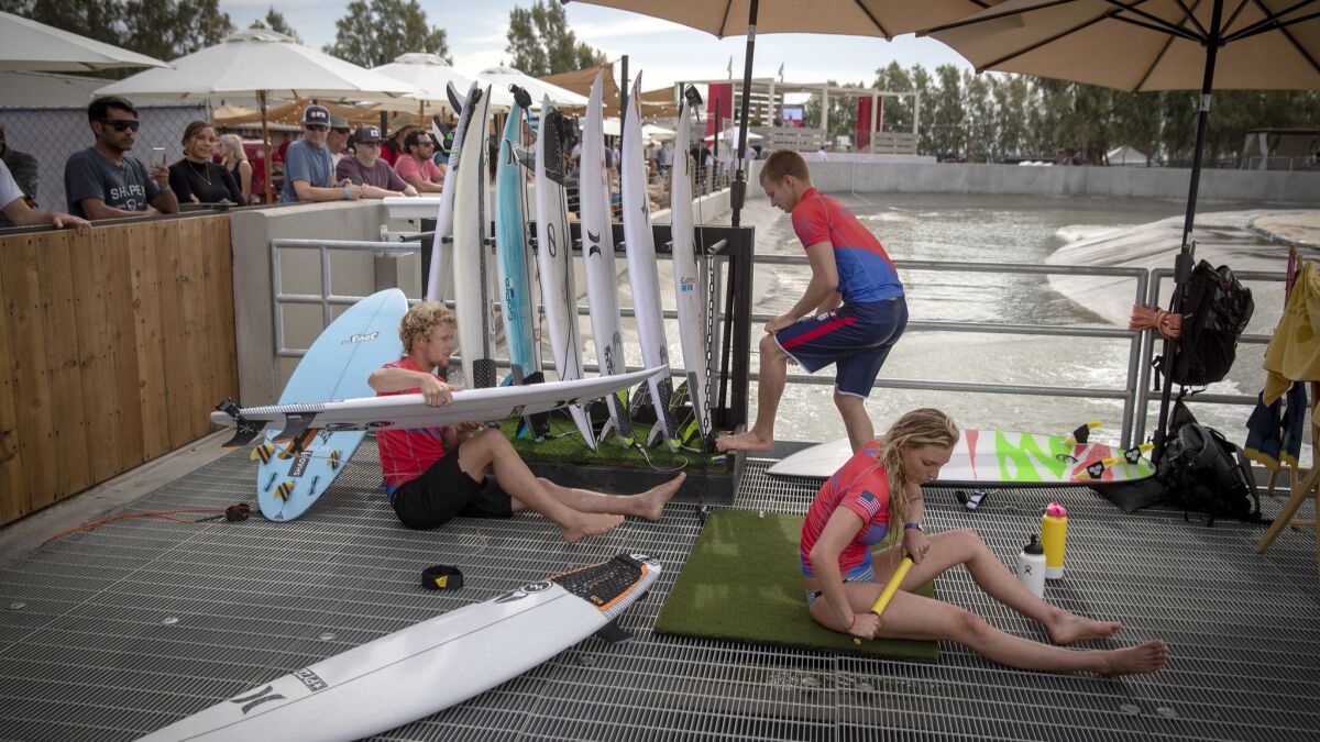 Pro surfers representing U.S.A. team John John Florence, left, Kolohe Andino, center, and Lakey Peterson, of Montecito, warm up and stretch before surfing.