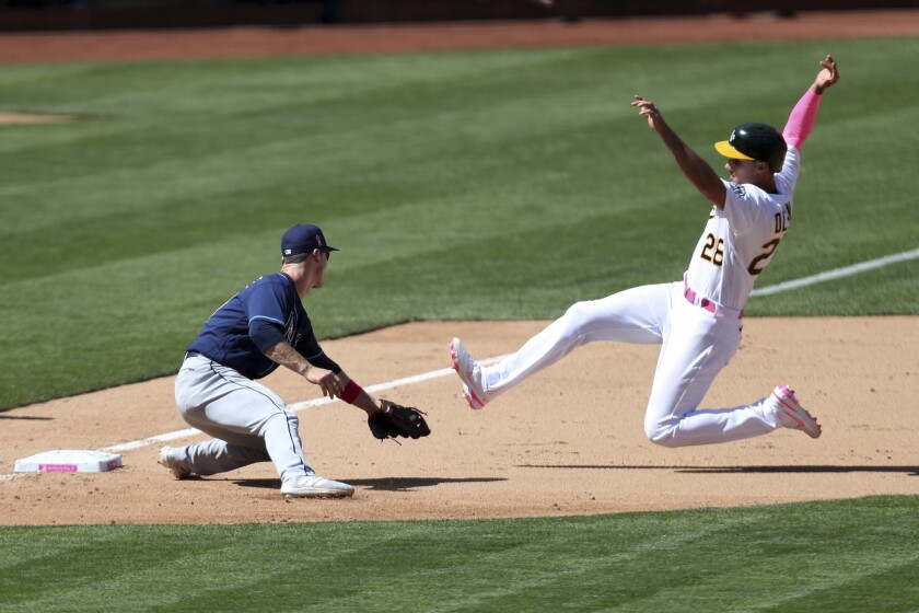 CORRECTS TO TAGGED OUT ON A PASSED BALL NOT A STEAL-ATTEMPT - Oakland Athletics' Matt Olson, right, is tagged out on a passed ball by Tampa Bay Rays' Joey Wendle during the eighth inning of a baseball game in Oakland, Calif., Sunday, May 9, 2021. (AP Photo/Jed Jacobsohn)