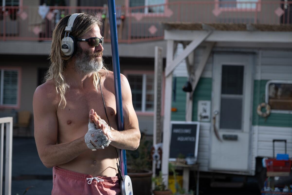 A shirtless, bearded Chris Pine in headphones as the titular "Poolman."